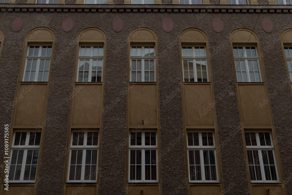 Obraz premium This is an exterior view of an impressive historic building facade that beautifully showcases its numerous windows along with various classic architectural details that contribute to its charm