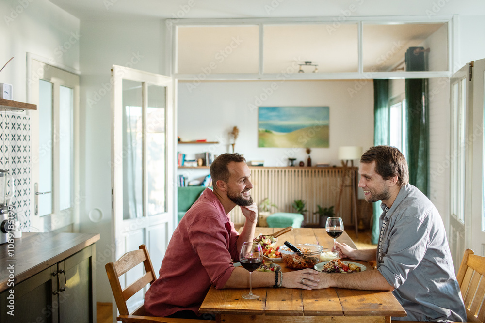 Gay couple eating meal together in the kitchen
