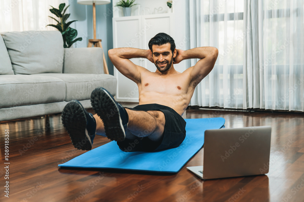 Athletic and sporty man doing crunch on fitness mat while follow online home workout exercise instruction for fit physique and healthy sport lifestyle at home. Online gaiety home exercise video. Athletic and sporty man doing crunch on fitness mat while follow online home workout exercise instruction for fit physique and healthy sport lifestyle at home. Online gaiety home exercise video.