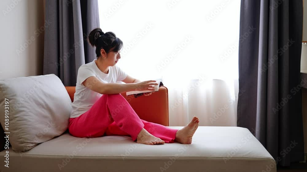 Women sitting on the sofa reading book Women sitting on the sofa reading book