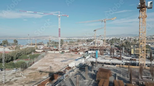 Aerial footage over big construction site with cranes photo