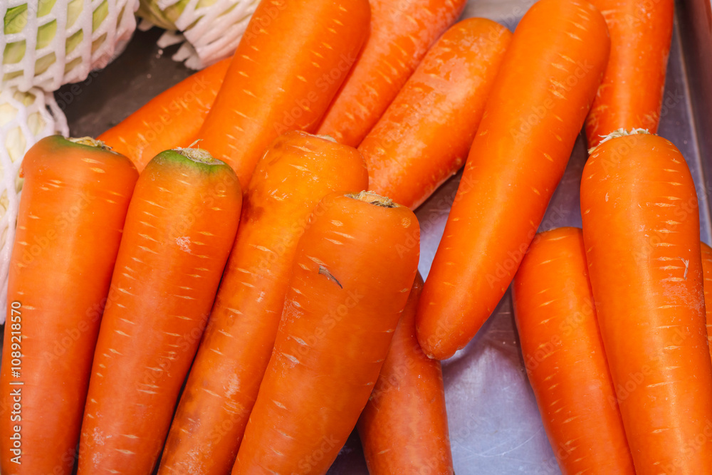 close-up view of several fresh, orange carrots placed together. The carrots are vibrant in color and appear to be clean and ready for consumption. close-up view of several fresh, orange carrots placed together. The carrots are vibrant in color and appear to be clean and ready for consumption.