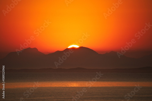 Sunset on the beach in Rio de Janeiro with the sea and mountains in the background. Postcard image