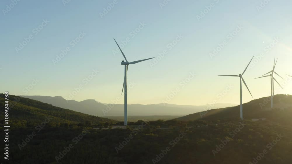 Aerial shot around a wind turbine turning at sunset in unspoilt nature, Provence, France Aerial shot around a wind turbine turning at sunset in unspoilt nature, Provence, France