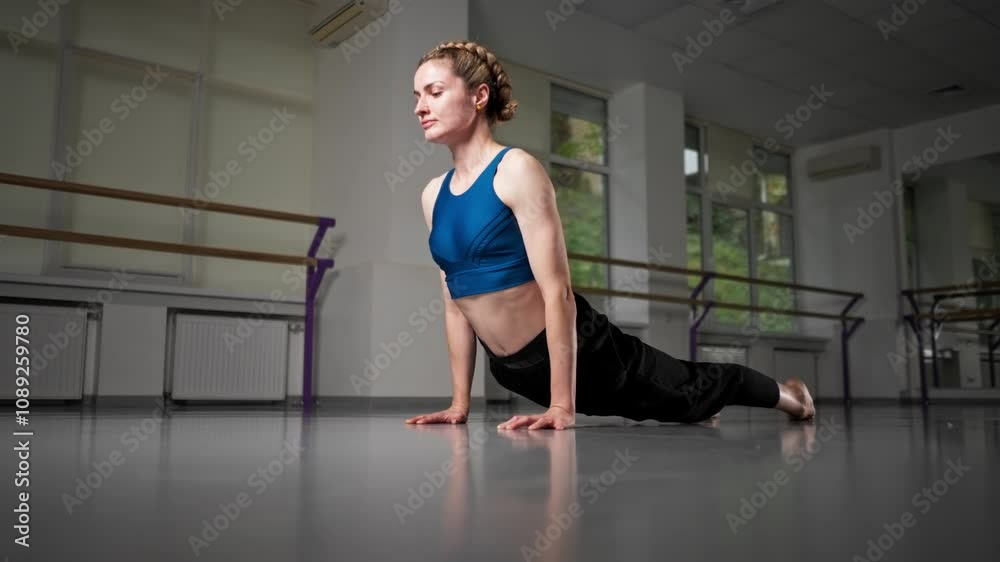 in the studio of spiritual development master class in yoga middle-aged girl in blue top and pants in a bright room pose asana warm-up for flexibility on the floor start of training in the studio of spiritual development master class in yoga middle-aged girl in blue top and pants in a bright room pose asana warm-up for flexibility on the floor start of training