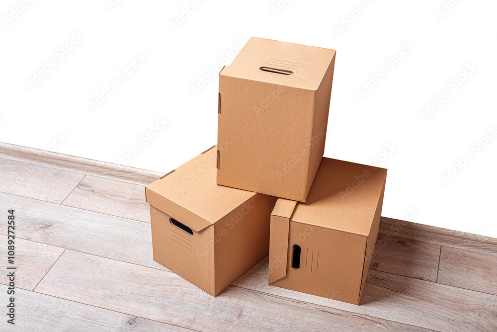 Mailing cardboard boxes on the floor against a white wall.