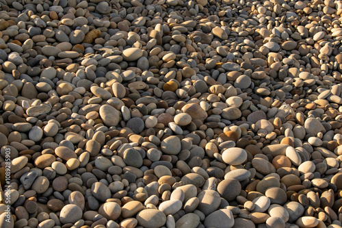 Runde Kiesel am Strand und Sonnenlicht