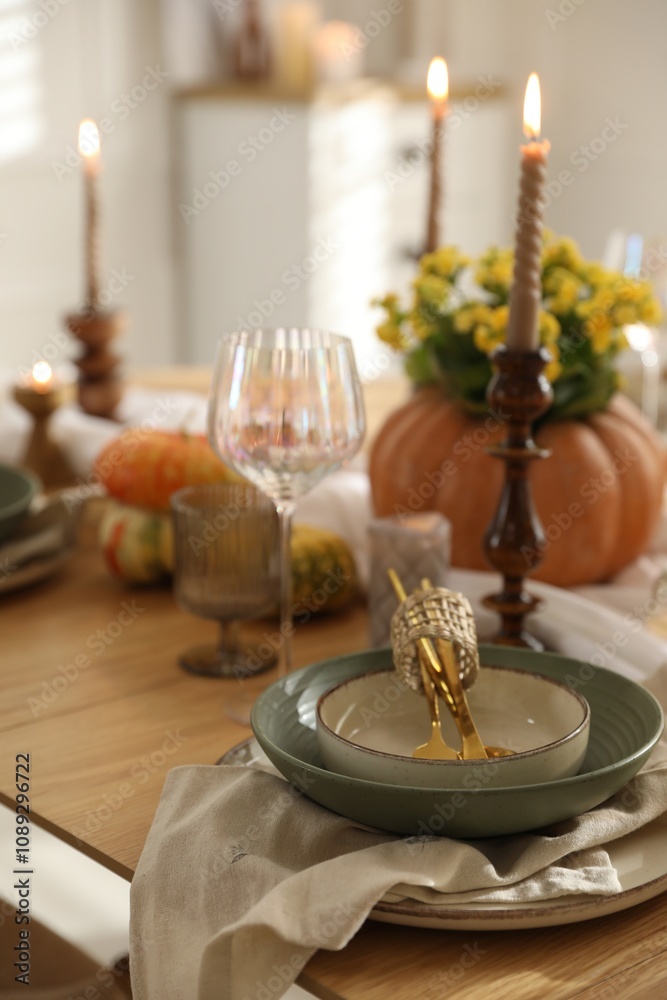 Stylish table setting with beautiful dishware, glasses and autumn decor in dining room Stylish table setting with beautiful dishware, glasses and autumn decor in dining room