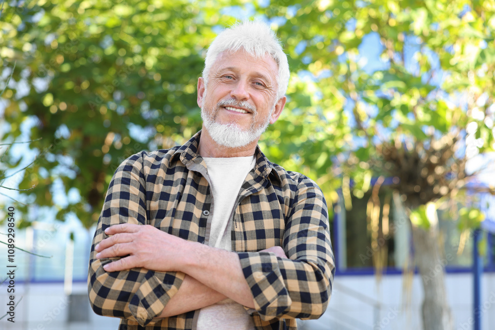 Portrait of smiling senior man with crossed arms outdoors Portrait of smiling senior man with crossed arms outdoors