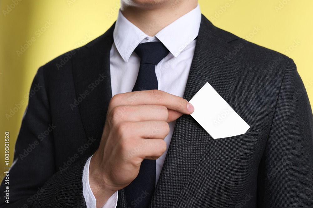 Man taking blank business card from pocket of his jacket on yellow background, closeup. Mockup for design Man taking blank business card from pocket of his jacket on yellow background, closeup. Mockup for design