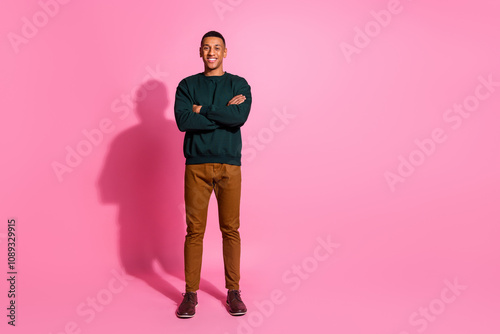 Full length photo of cheerful positive guy dressed pullover arms crossed emtpy space isolated pink color background