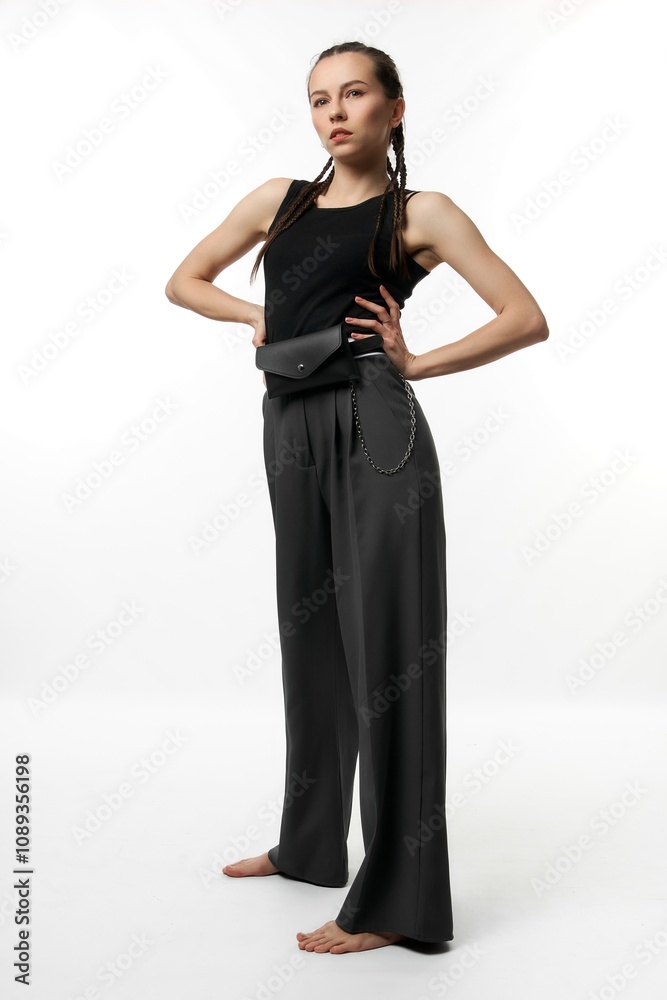 Girl model with pigtails in black T-shirt poses in studio on white background Girl model with pigtails in black T-shirt poses in studio on white background