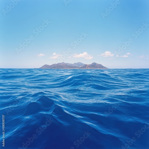 serene ocean view with distant island under a clear blue sky