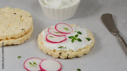Round puffed crispy diet rice cake with cream cheese and radish.