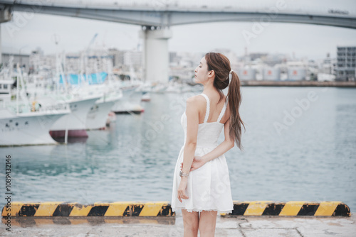 Woman enjpy view of fishing port harbor, Okinawa, Japan. photo