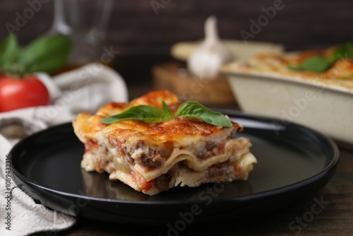 Delicious cooked lasagna with basil on table, closeup