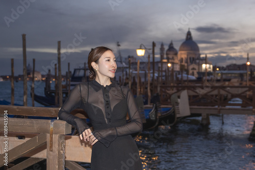 Woman with night view of gondolas, canals and old town background Italy, Venice.