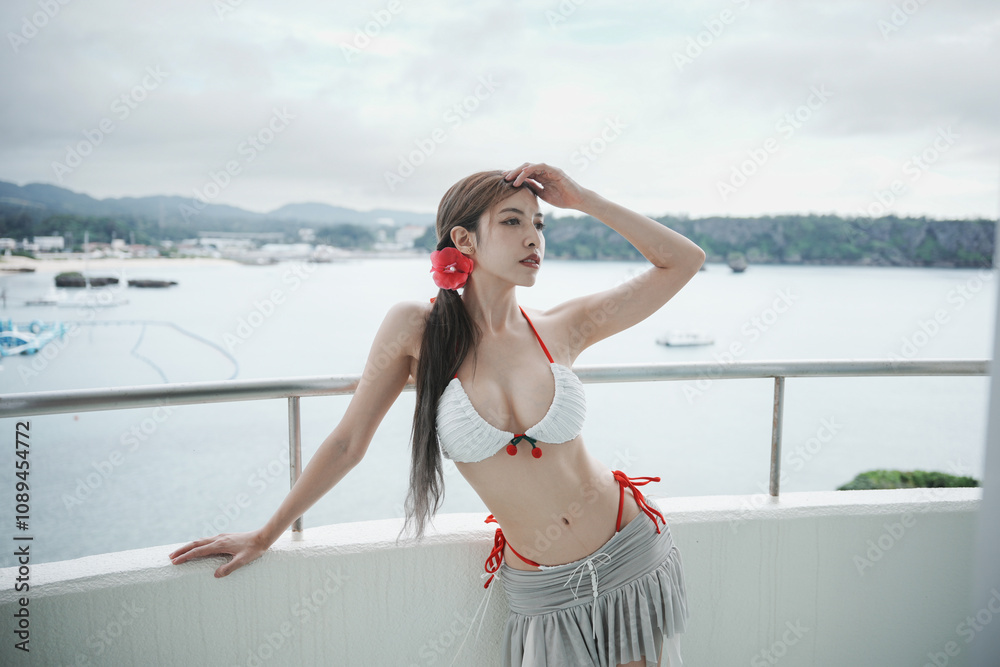 Naklejka premium Woman wearing bikini enjoy ocean view from beachfront balcony tropical resort.