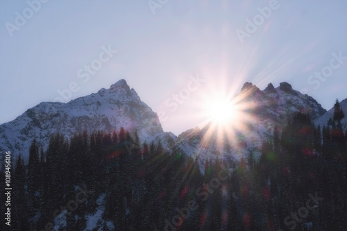 Sunset in the harsh and rocky winter mountains when the sun rays hide behind the rocks. Issyk Gorge Almaty Kazakhstan