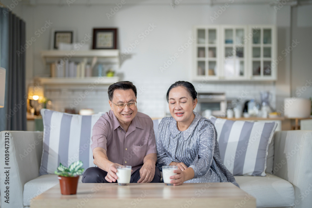 An elderly couple enjoys a peaceful moment at home, sharing smiles and drinks. The warm and cozy atmosphere emphasizes their deep connection, happiness, and the comfort of spending time together. An elderly couple enjoys a peaceful moment at home, sharing smiles and drinks. The warm and cozy atmosphere emphasizes their deep connection, happiness, and the comfort of spending time together.