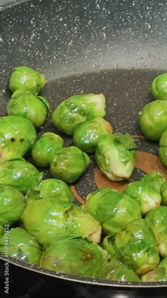 Brussels sprouts close up cooking in a frying pan for breakfast. Healthy food and green vegetables for better health and fitness diet. Cooking process in a frying pan in the kitchen Brussels sprouts close up cooking in a frying pan for breakfast. Healthy food and green vegetables for better health and fitness diet. Cooking process in a frying pan in the kitchen