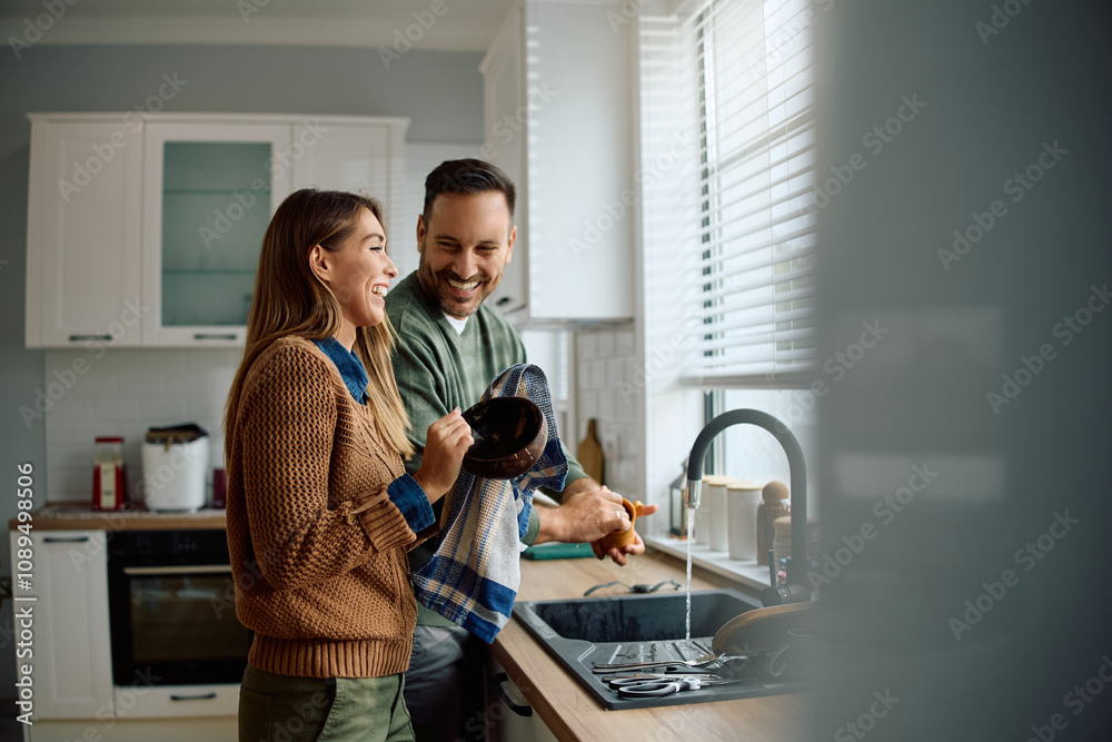 Happy couple having fun while doing dishes together. Happy couple having fun while doing dishes together.