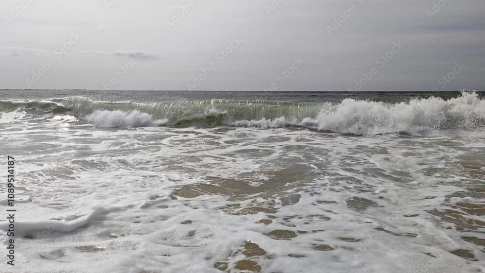 große kräftige Wellen brechen auf flachen Sandstrand in Zeitlupe, Küste, Meer, Brandung, Wasser, Energie, Natur, Landschaft