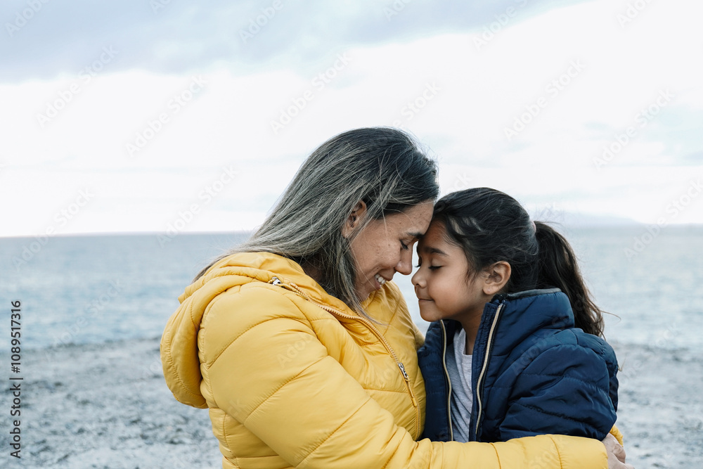 Winter, Hispanic mother and daughter having hug together during travel holiday vacations. Family, love concept Winter, Hispanic mother and daughter having hug together during travel holiday vacations. Family, love concept