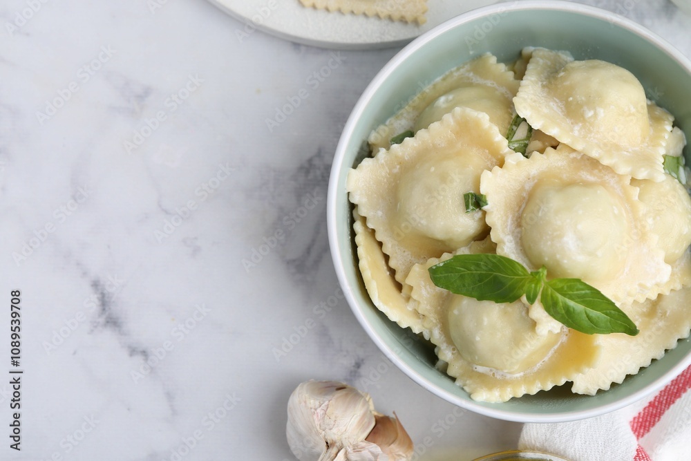 Delicious ravioli with cheese and basil served on white marble table, top view. Space for text Delicious ravioli with cheese and basil served on white marble table, top view. Space for text