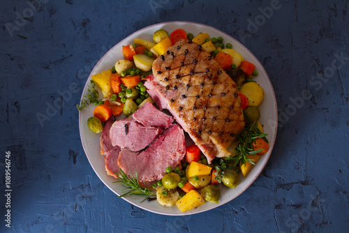 Clove baked ham with potatoes, carrots, turnip and brussel sprouts. View from above, top studio shot