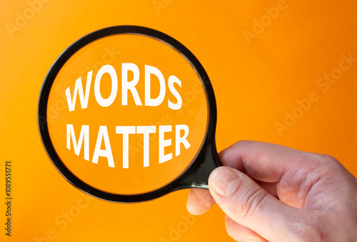 Words Matter symbol. Magnifying Glass with Concept word Words Matter. Businessman hand. Beautiful orange background. Business and Words Matter concept. Copy space