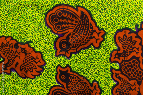 top view of green orange ankara fabric, flatlay of nigerian wax cloth with designs, spread out green ankara material photo