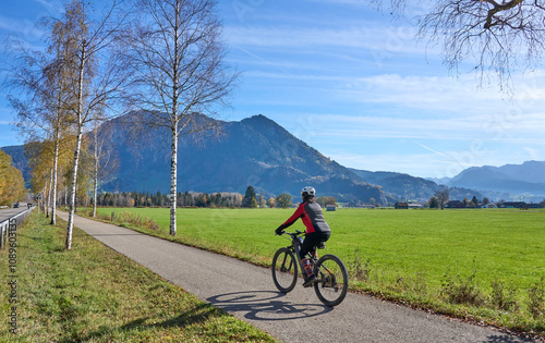 woman riding her electric mountain bike on the Allgaeu mountains , below Gruenten summit near Immenstadt,Bavaria Germany photo