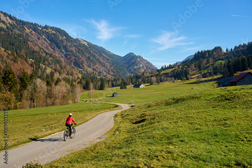 woman riding her electric mountain bike in the Leckner Valley in the Bregenz Forest Mountains near Hittisau, Vorarlberg, Austria