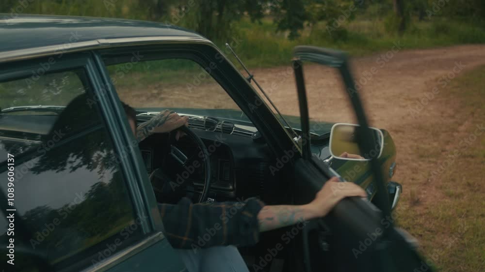 A woman abruptly gets out of a retro car when she sees smoke coming from under the hood