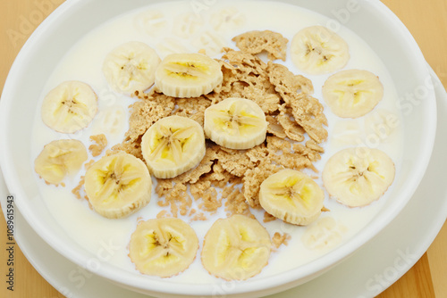 A bowl of cereal with bananas and milk. A banana, milk, and milk cereal with fruit. Cereal milk fruit banana breakfast slice plate. A plate of cereal, bananas, and a lifestyle slice of banana.