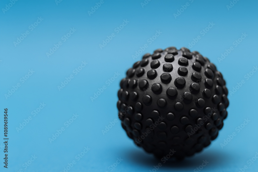 A black egg on a blue background. Black and blue ball on a blue background. Black ball blue background game round lies. A round of blue ball lies on the background lifestyle of a game.