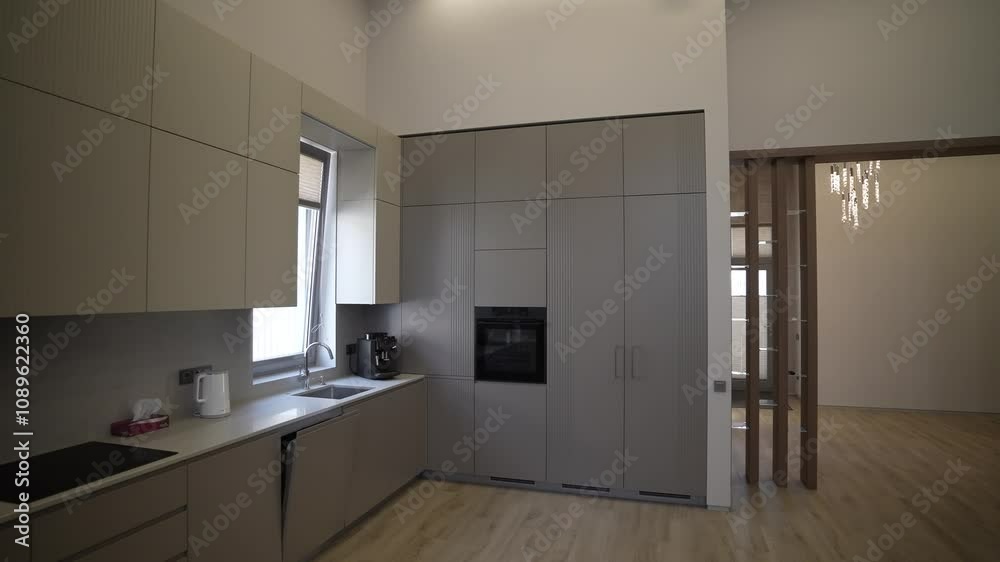 This modern minimalist kitchen features a sleek design with plenty of natural light This modern minimalist kitchen features a sleek design with plenty of natural light