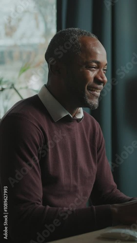 Portrait of happy emotional man sitting at computer and reading message with good news. Footage of joyful businessman working in front of monitor at home office. Indoors. Remote job