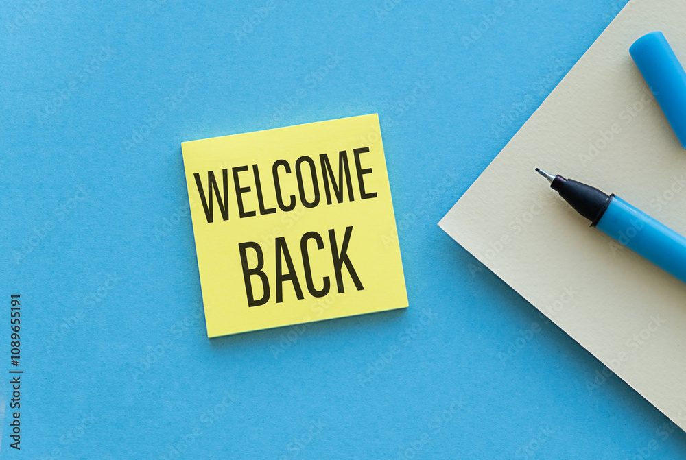 Paper notes with the words Welcome Back on Yellow Sticky on blue table, top view. Paper notes with the words Welcome Back on Yellow Sticky on blue table, top view.