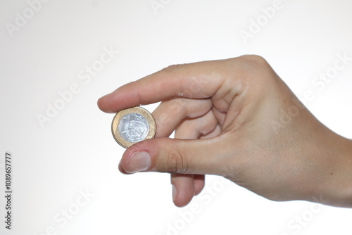 Hand Holding a 1 Real Coin, Showcasing the Coin's Unique Design and Textures