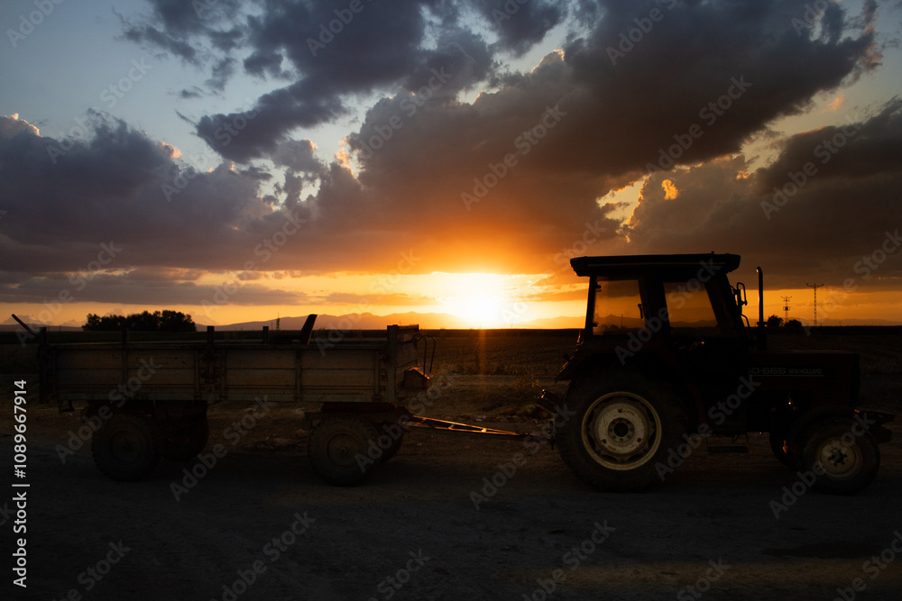 magnificent sunset and tractor view in agricultural field magnificent sunset and tractor view in agricultural field