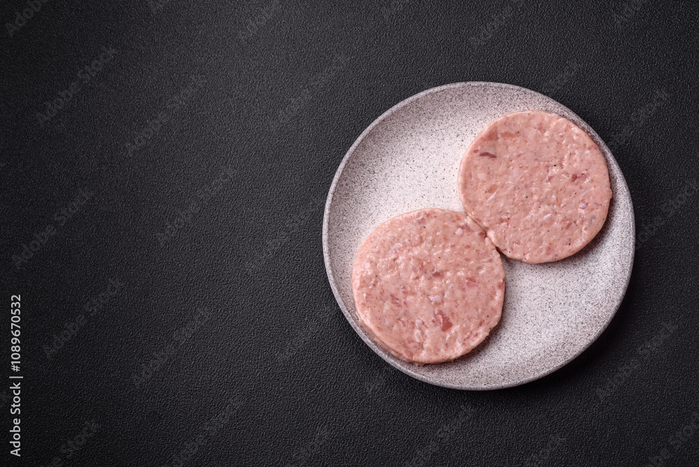 Naklejka premium Raw chicken burger cutlet with salt, spices and herbs
