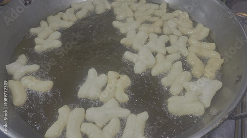 Patongko, deep-fried dough stick in a pan with boiling oil