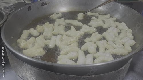 Patongko, deep-fried dough stick in a pan with boiling oil