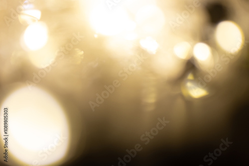 Golden brown Christmas bokeh background. Blurred white garland lights background with glitters and soft reflections for rendering, greeting cards and postcards. Blurry vintage gold abstraction.