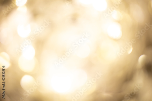 Golden brown Christmas bokeh background. Blurred white garland lights background with glitters and soft reflections for rendering, greeting cards and postcards. Blurry vintage gold abstraction.