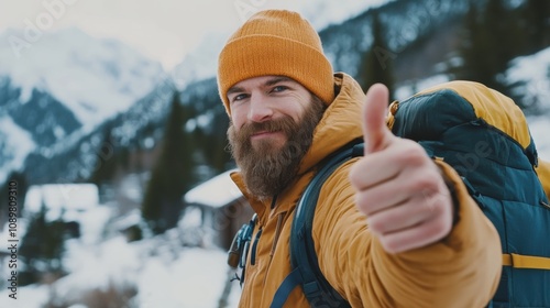 Man gives thumbs up during winter hike in snowy mountains