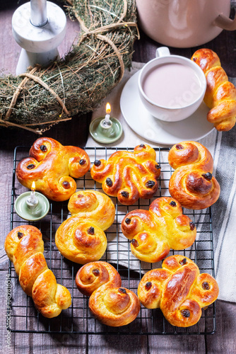Obraz na płótnie Traditional saffron Swedish buns lussekatt in different shapes, served with cocoa on a wooden table. Buns for St. Lucia's Day. w salonie