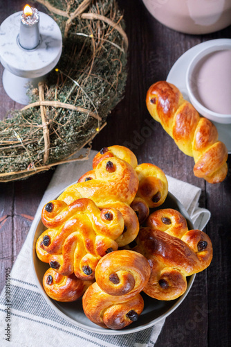 Obraz na płótnie Traditional saffron Swedish buns lussekatt in different shapes, served with cocoa on a wooden table. Buns for St. Lucia's Day. w salonie